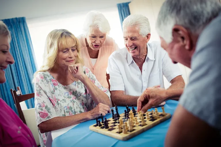 photo of seniors sitting around a table playing chess